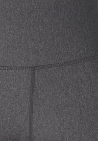 Legginsy o wysokim stanie w ciemnoszarym kolorze, wykonane z gładkiego, teksturowanego materiału, z widocznymi detalami szwów. Brak wzorów lub metalowych akcentów.