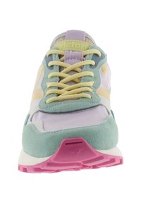 Vooraanzicht van een sneaker in pasteltinten met gele veters, mintgroene suède overlays en een roze rubberen zool.