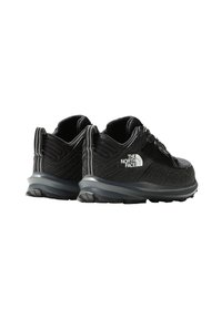 Chaussures de randonnée noires avec tige en textile, col rembourré et semelle extérieure en caoutchouc. Avec des accents réfléchissants et un logo de marque sur le côté.