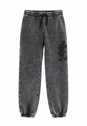 Mørkegrå sweatpants med elastisk talje og ankler, med en sort silhuet af en tegneseriefigur på højre ben.