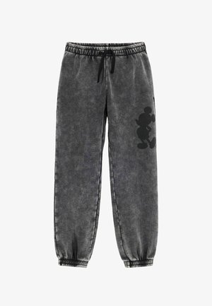 Mørkegrå sweatpants med elastisk talje og ankler, med en sort silhuet af en tegneseriefigur på højre ben.