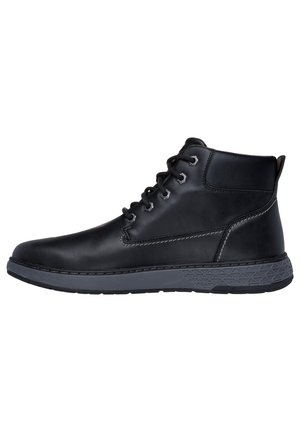 Botas de cuero negro hasta el tobillo con un acabado suave, suelas de goma grises, diseño de cordones y detalles de costura en contraste.