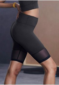 Hoch taillierte schwarze Sportshorts mit Mesh-Einsätzen, glattem Stoff, figurbetontem Design und elastischem Bund. Verfügt über dezente Nähte und Akzente.
