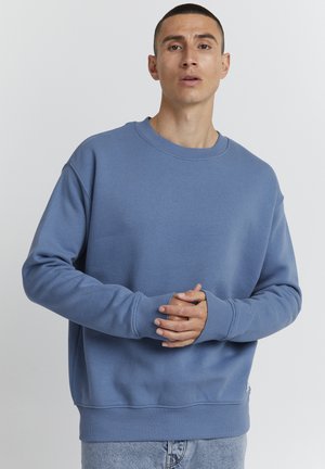 Blå sweatshirt lavet af blødt stof, med rund hals, ribbede manchetter og kant, i en løs pasform og uden fremtrædende mønstre.