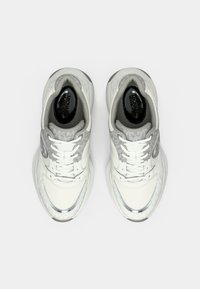 Λευκά και γκρι αθλητικά παπούτσια με υφασμένο επάνω μέρος, κορδόνια και αντανακλαστικές λεπτομέρειες. Διαθέτουν εμφανές λογότυπο στο πλάι και μαλακή σόλα.