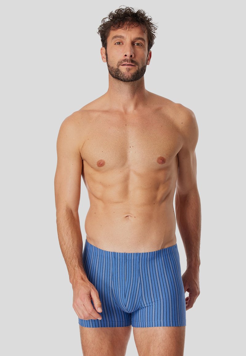 Boxer di colore blu a righe realizzati in tessuto morbido e elastico. Presentano un cinturino orizzontale e una vestibilità aderente lungo le gambe.