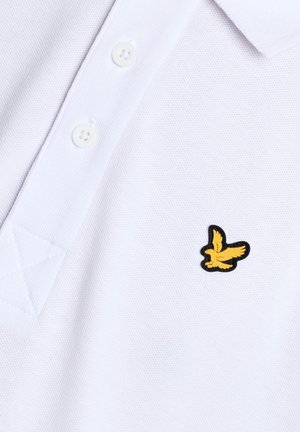 Polo bianca con due bottoni bianchi e un piccolo logo di uccello giallo ricamato sul petto.