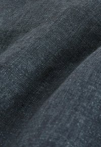 Tissu tissé gris foncé avec une surface texturée, arborant un éclat subtil et des fils variés dans un motif doux et fluide.