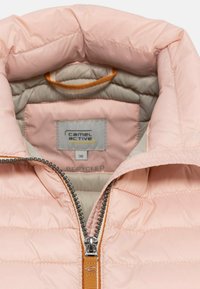 Helles pinker, puffy Jacke mit einem silbernen Reißverschluss, orangefarbenem Akzent am Reißverschluss und einem beigen Futter. Enthält ein Etikett, das "recyceltes" Material zeigt.