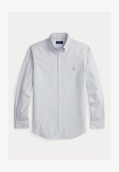 Φουλάρι με κάθετες ανοιχτό μπλε και λευκές ρίγες, μακρυμάνικο πουκάμισο με κουμπιά, γιακά με κουμπιά και μικρό κεντημένο λογότυπο στο στήθος.