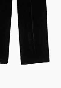 Black velvet trousers with a smooth texture, wide leg design, and no visible hardware or accents, laid flat against a white background.