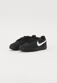 Baskets noires en suède et en mesh avec un swoosh Nike blanc. Comprend des lacets, une semelle en caoutchouc et un design à bout rond.