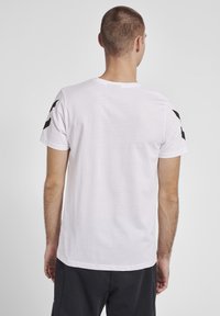 Hvid bomuld t-shirt med sorte sideakcenter. Klassisk crew neck-design med korte ærmer, glat tekstur og en afslappet pasform.