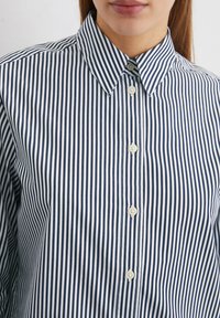 Marineblauw en wit gestreept shirt met een klassieke kraag, vijf knopen aan de voorkant en een gladde katoentextuur.
