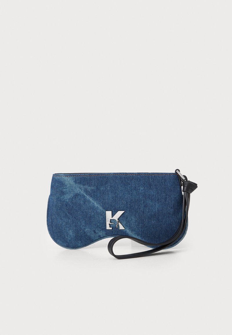 Pochette in denim con forma curva, caratterizzata da un logo a "K" metallico argentato e un cinturino per il polso nero. Tessuto leggermente vissuto.