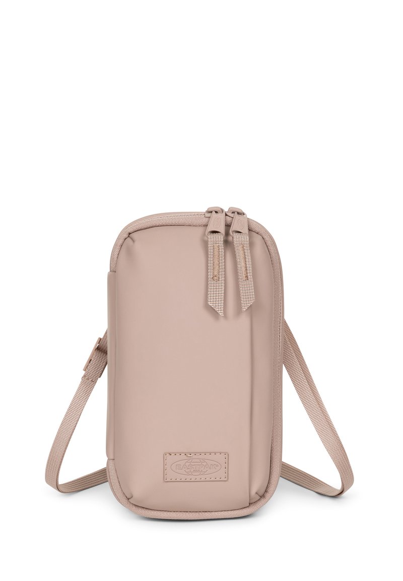 Sac bandoulière compact beige en matériau synthétique lisse, avec fermeture à double zip et sangle réglable. Badge logo à l'avant.