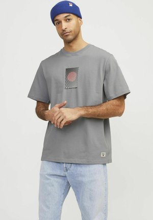 Grijze katoenen t-shirt met een geometrische grafiek in rood, zwart en wit, met korte mouwen en een klein logo-label aan de zoom.