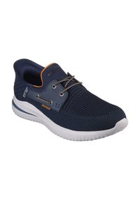 Marineblauwe sportschoen met een ademende mesh bovenzijde, gestructureerd ontwerp, oranje accenten en een witte rubberen zool. Voorzien van elastische veters.