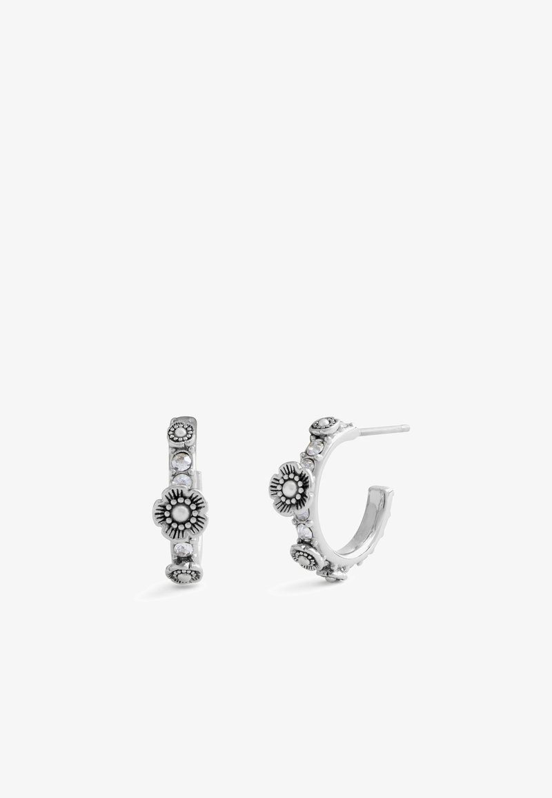 Silver hoop earrings adorned with floral patterns, small clear crystals, and intricate detailing along the outer edge.