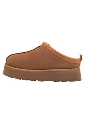 Mocassin en daim marron à enfiler avec une bande d'accent orange texturée, semelle plate-forme légère et logo embossé sur le côté.