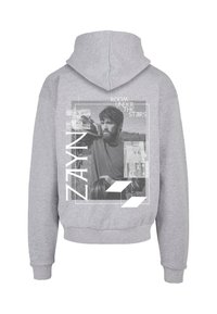 Grå hættetrøje med et grafisk print på ryggen, der viser et portræt og teksten "ROOM UNDER THE STAIRS" sammen med navnet "ZAYN."