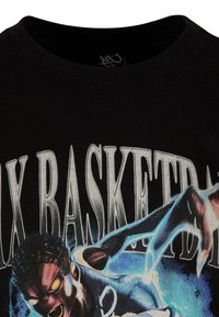 Czarny bawełniany t-shirt z dużym graficznym nadrukiem postaci z świecącymi oczami, z wyciągniętymi rękami i napisem "BASKETBALL" w pogrubionych literach.