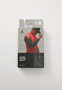 Confezione nera con uno sfondo grigio e linee astratte. Mostra una manica atletica rossa etichettata "Jordan Fly Elite Sleeve", taglia S-M.