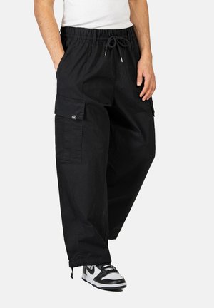Black cargo pants with an elastic waistband, drawstring, and multiple pockets. Made from a durable fabric, featuring a relaxed fit and tapered cuffs.
