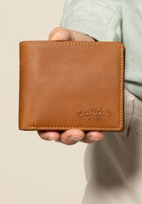 Portafoglio in pelle marrone con texture naturale, con cuciture bianche e logo "Gusti Leder studio" in rilievo. Design pieghevole.