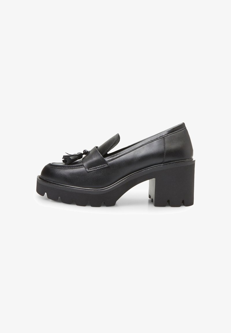 Mocassin en cuir noir à talon épais et semelle plateforme, orné de pompons à l'avant et semelle extérieure striée pour l'adhérence.