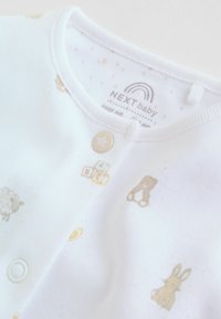 Body pour bébé blanc avec motifs d'animaux et de blocs dorés, col rond, boutons-pression et texture de tissu douce.