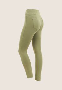 Leggings verde oliva con una cintura alta, que presentan un diseño ajustado, costuras decorativas y dos bolsillos traseros con acentos de hardware en tono dorado.