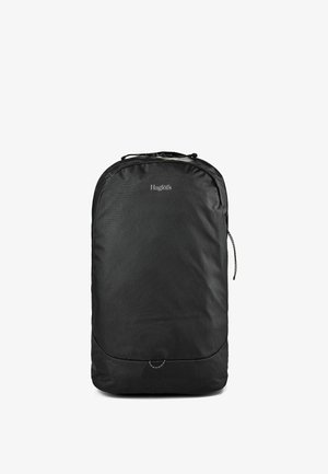 Sac à dos noir Haglöfs avec une forme rectangulaire simple, une fermeture éclair sur le dessus et une petite boucle près du centre inférieur.