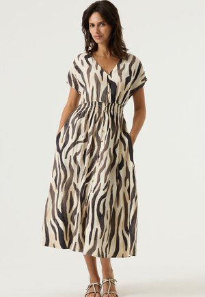 Robe légère à motif avec un col en V, manches courtes, taille cintrée et poches, arborant un imprimé animal beige et noir.