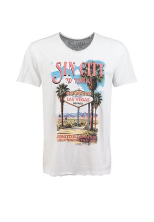 Weißes T-Shirt mit dem Aufdruck "Sin City No Regrets" und einer Grafik des Las Vegas-Schilds, umgeben von Palmen und Wüstenlandschaft.