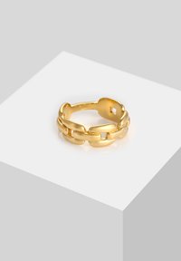 Bague en or avec un design de chaîne maillée, présentant des bords lisses et arrondis ainsi que de petits espaces ouverts entre les maillons, reflétant la lumière.