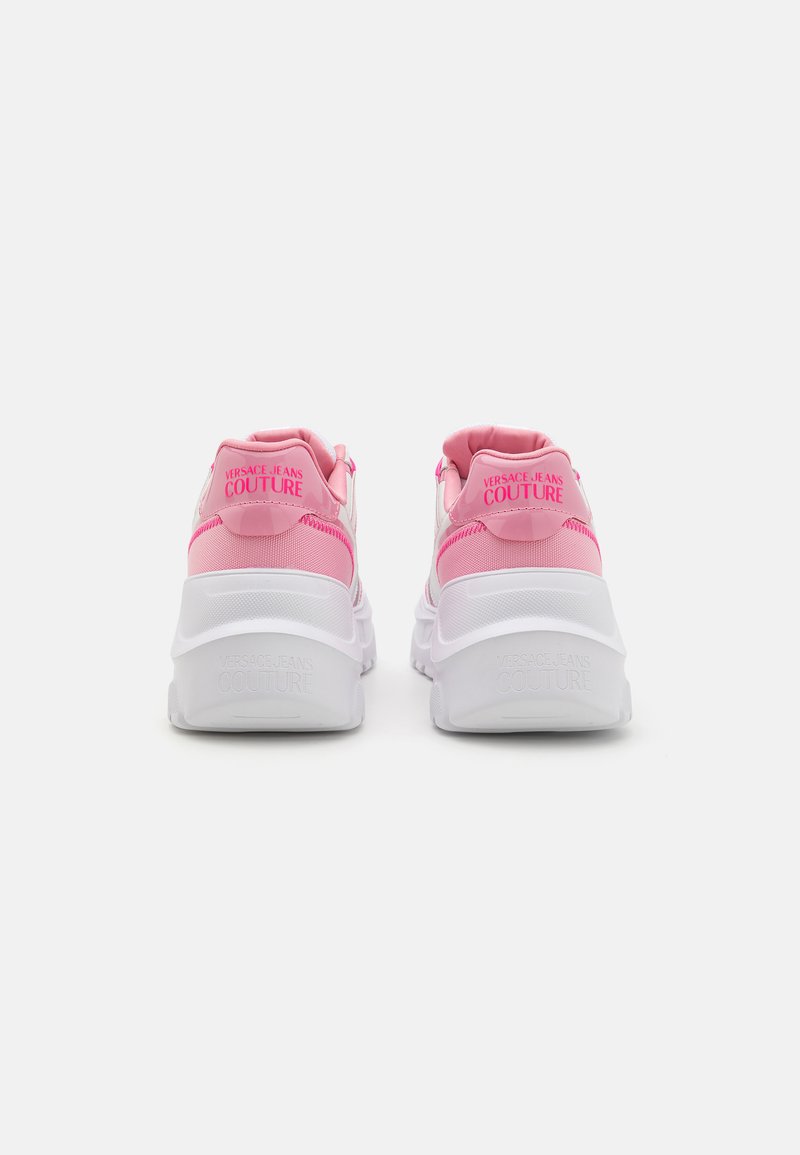 Roze en witte sneakers met een chunky zool, voorzien van een gestructureerde afwerking en logodetails op de hiel en tong.