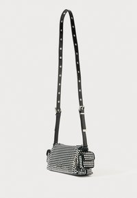 Schwarze Handtasche mit strukturiertem Design, bedeckt mit silbernen Nieten, ausgestattet mit einem langen verstellbaren Tragegurt und einer kleinen Fronttasche.