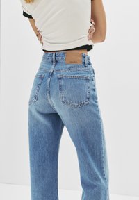 Ljusblå högmidjade jeans med rak ben. Har en ficka på baksidan och en brun läderetikett med varumärkesnamnet.