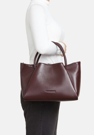 Burgundy leather handbag with a triangular design, two top handles, and a smooth texture. Features a subtle brand logo on the front.