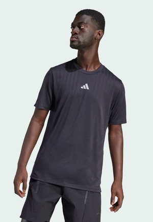 Black athletic t-shirt made of lightweight fabric, featuring short sleeves and a round neckline. It has a small white logo on the chest.