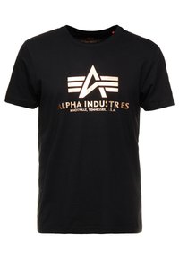 Zwarte t-shirt met korte mouwen met een metallic gouden Alpha Industries-logo en de tekst "Knoxville, Tennessee, U.S.A." op het midden van de voorkant.