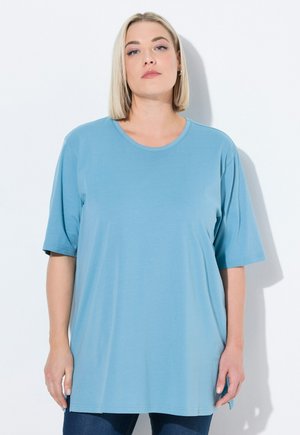 T-shirt oversize azzurro chiaro realizzato in tessuto morbido, con scollatura rotonda e maniche corte, dal fit rilassato e fessure laterali all'orlo.