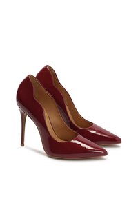 Burgundy patent leather high heels with pointed toes and a cutout design at the sides, featuring slender stiletto heels.