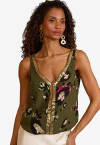 Olive green tank top with a v-neckline featuring a leopard print pattern in black, pink, and cream. Gold sequined trim along the neckline.