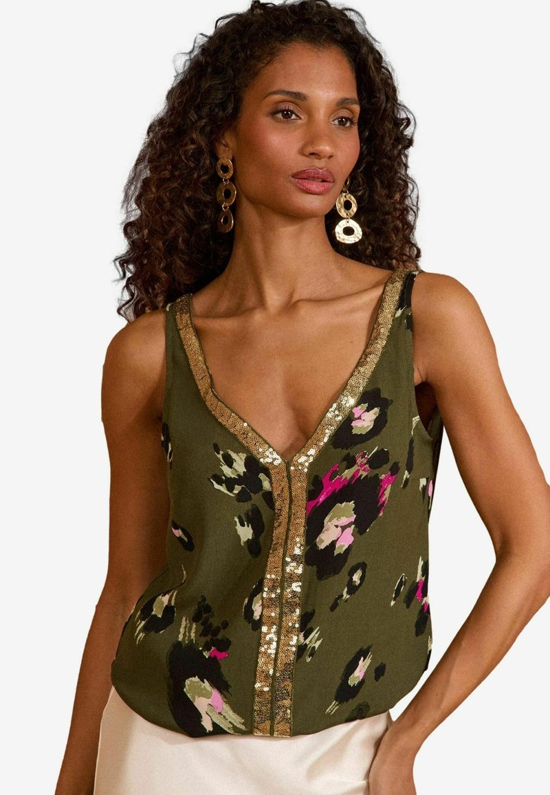 Olive green tank top with a v-neckline featuring a leopard print pattern in black, pink, and cream. Gold sequined trim along the neckline.