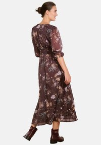 Langes, blumendes Kleid mit einem dunkelvioletten Hintergrund und verschiedenen pastellfarbenen Blumen, Puffärmeln, einer taillierten Taille und einem fließenden Rock.