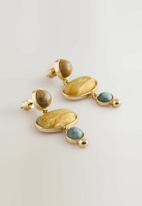 Goldfarbene Ohrringe mit gelben und braunen Dekorsteinen, akzentuiert durch blaue Steine und glänzende kugelförmige Details.