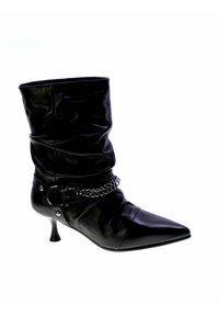 Stivale in pelle nera con canna arricciata, punta affusolata e tacco a stiletto. Presenta un accento in catena attorno alla caviglia con borchie metalliche.