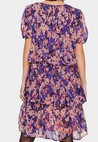 Vestito a stampa floreale in tessuto trasparente, caratterizzato da un design a balze con maniche corte arricciate e una palette di colori rosa, viola e blu.